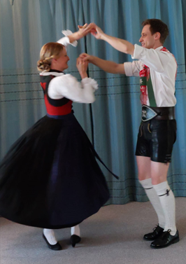 Bild zeigt ein Pärchen in Tracht, das tanzt.