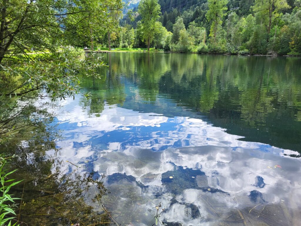Bild zeigt einen Teich und die Spiegelung der Wolken im Wasser
